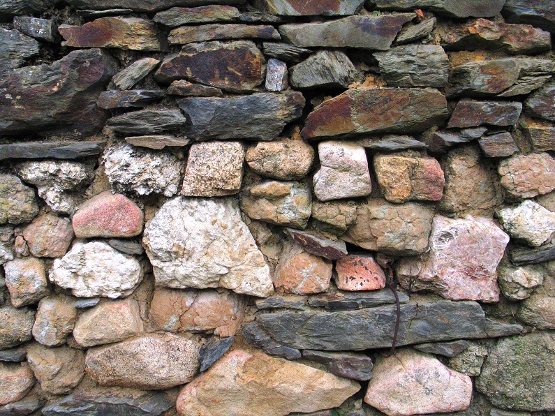 Muro com pedras ligadas por argamassa. Note-se a diversidade da litologia e a dimensão e forma dos vários elementos, cuja disparidade motiva a utilização da argamassa como forma eficaz de manter a estrutura